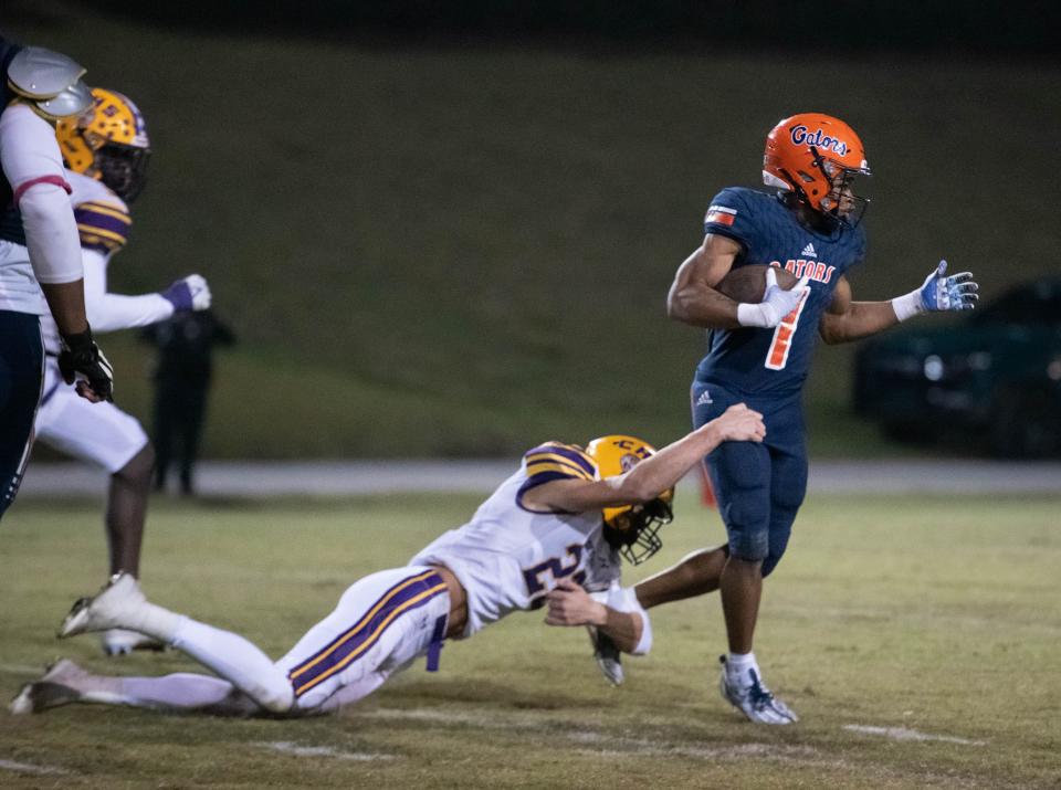 Akeem Stokes (1) is tackled by Brett Mote (22) during the Columbia vs Escambia FHSAA Class 3S state tournament playoff football game at Escambia High School in Pensacola on Friday, Nov. 18, 2022.