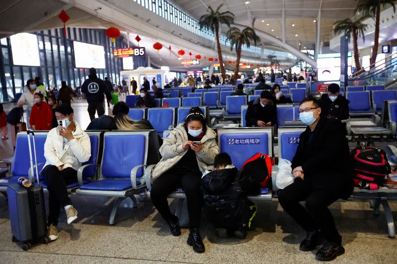 FOTO DE ARCHIVO. Varias personas esperan con sus maletas en una estación de ferrocarril, en medio del brote de la enfermedad por coronavirus (COVID-19), en Wuhan, provincia china de Hubei