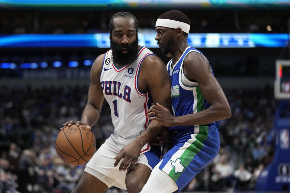 Philadelphia 76ers guard James Harden (1) works against Dallas Mavericks forward Justin Holiday (0) in the first half of an NBA basketball game, Thursday, March 2, 2023, in Dallas. (AP Photo/Tony Gutierrez)