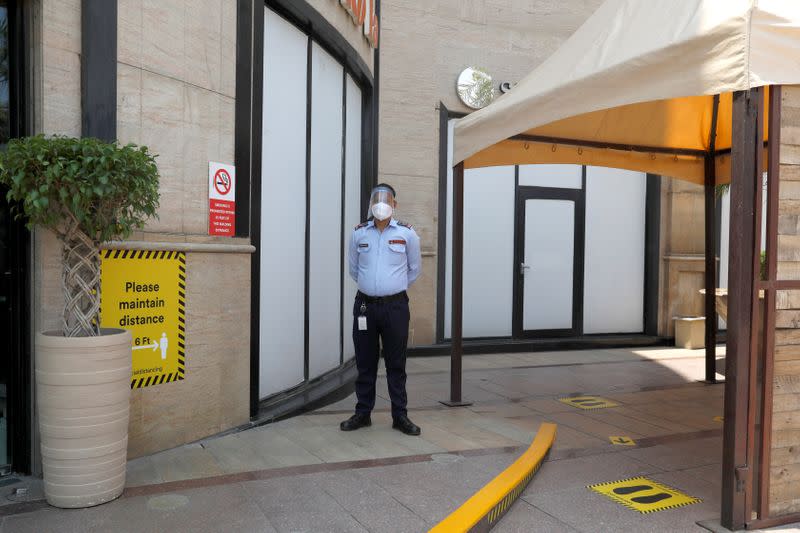 A security guard wearing a protective face shield is seen at the entrance of a mall ahead of its reopening during an extended nationwide lockdown to slow down the spread of the coronavirus disease (COVID-19), in New Delhi