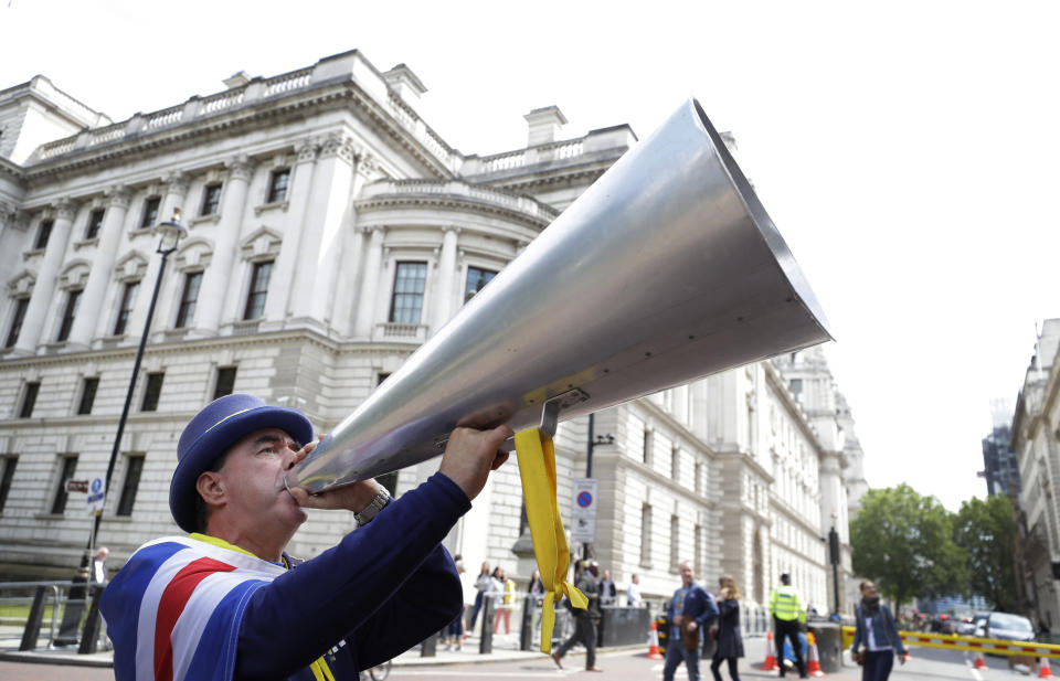 Anti Brexit campaigner Steve Bray shouts through his megaphone outside Conservative leadership contender press conferences, in London, Tuesday, June 11, 2019. (AP Photo/Kirsty Wigglesworth)