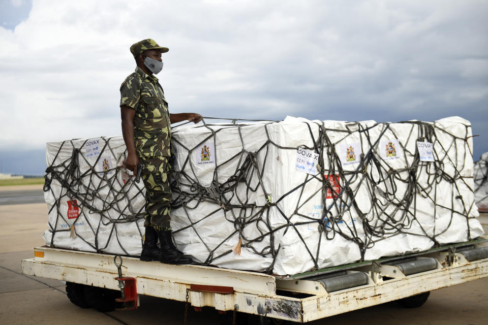 FILE - In this Friday, March 5, 2021 file photo, a Malawian policeman guards AstraZeneca COVID-19 vaccines after the shipment arrived at the Kamuzu International Airport in Lilongwe, Malawi. Some Africans are hesitating to get COVID-19 vaccines amid concerns about their safety, alarming public health officials as some countries start to destroy thousands of doses that expired before use. (AP Photo/Thoko Chikondi, File)