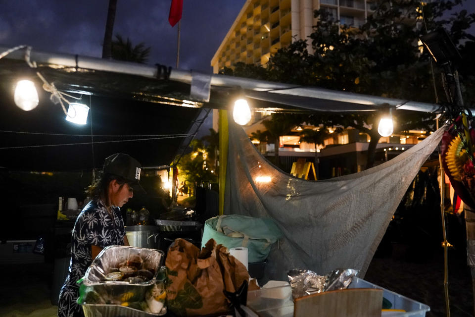 Displaced Lahaina wildfire survivor Lily Nguyen, who says she and her daughter fled into the ocean water for five hours to escape the fire, prepares pho at a Fishing for Housing protest Wednesday, Dec. 6, 2023, Kaanapali Beach in Lahaina, Hawaii. "Almost four months now and we live day by day, we don't know what to do," Nguyen said. A group of survivors is camping on the resort beach to protest and raise awareness for better long-term housing options for those displaced. (AP Photo/Lindsey Wasson)