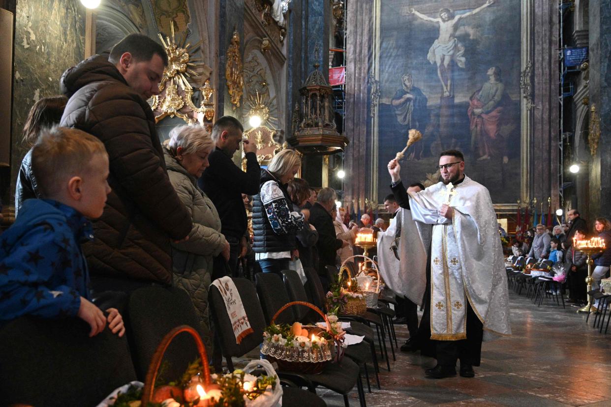 A priest blesses traditional cakes and eggs during a service at Saints Peter and Paul Garrison Church on the eve of Orthodox Easter in western Ukrainian city of Lviv (AFP via Getty Images)