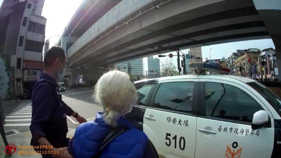 臺北市保安警察大隊第五中隊員警護送婦人上警車平安返家。（台北市保安警察大隊提供）