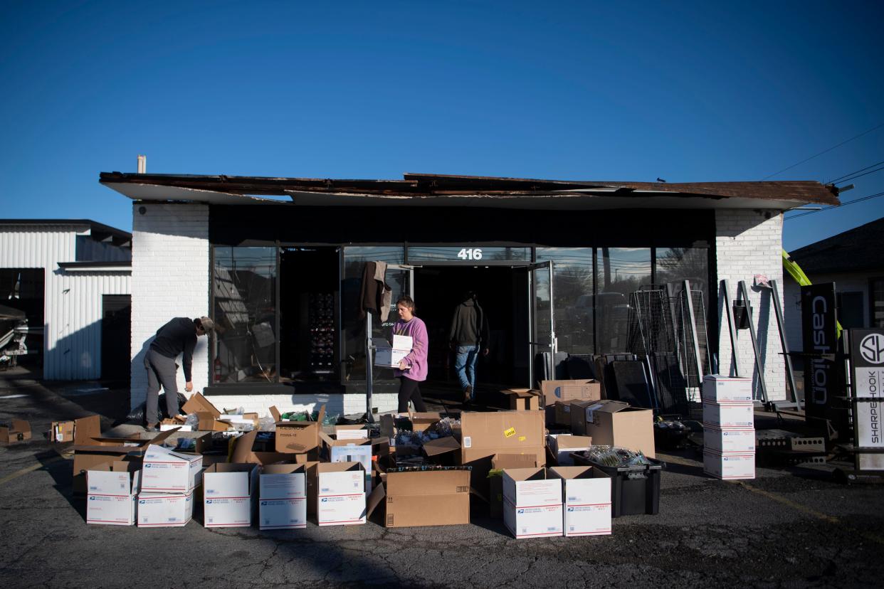 Mackenzie Winchester carries out boxes of fishing products outside of Sharpe Hook Bait and Tackle on Main Street in Hendersonville, Tenn., Sunday, Dec. 10, 2023.