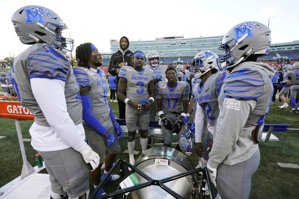 Memphis players stand by a portable heater on the sidelines during the second half of the First Responder Bowl NCAA college football game against Utah State, Tuesday, Dec. 27, 2022, in Dallas. (AP Photo/Sam Hodde)