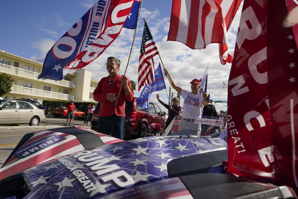 Supporters of President Donald Trump wave as they wait for the motorcade on the road to Mar-a-Lago, Trump's Palm Beach estate, on Wednesday, Jan. 20, 2021, in West Palm Beach, Fla. (AP Photo/Lynne Sladky)