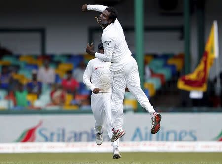 Sri Lanka's captain Angelo Mathews celebrates after taking the wicket of India's captain Virat Kohli (not pictured) on the second day of their third and final test cricket match in Colombo, August 29, 2015. REUTERS/Dinuka Liyanawatte