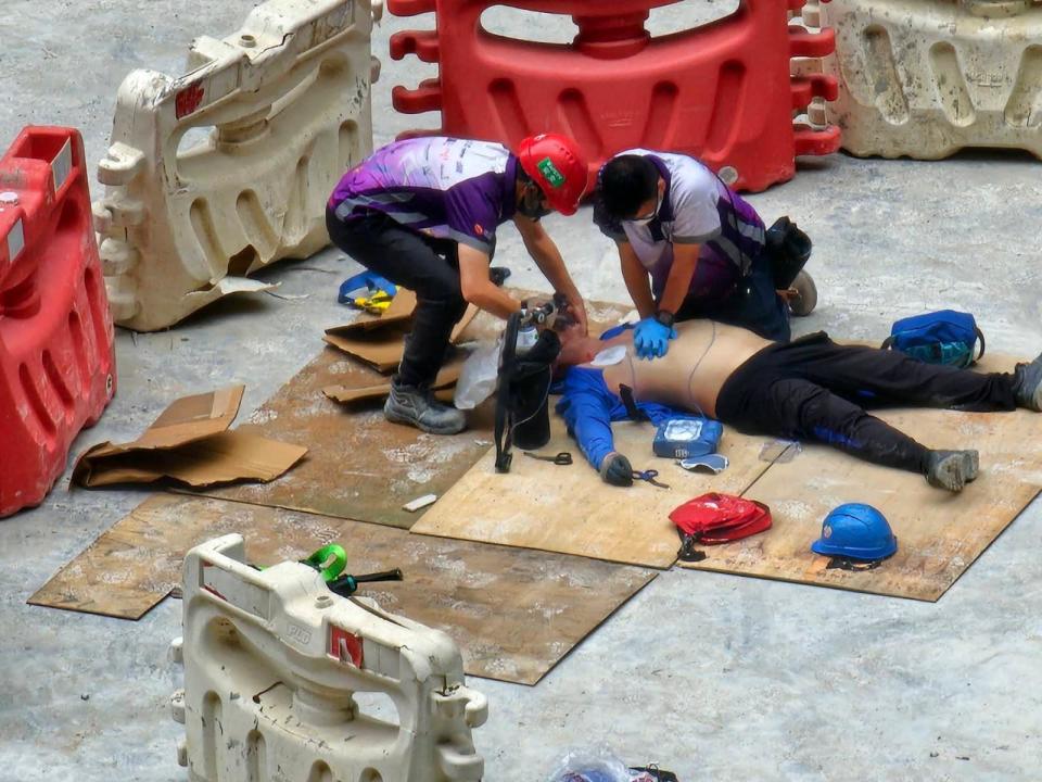 網上圖片顯示，現場有救護員為暈倒男工人進行急救。(香港突發事故報料區@fb圖)