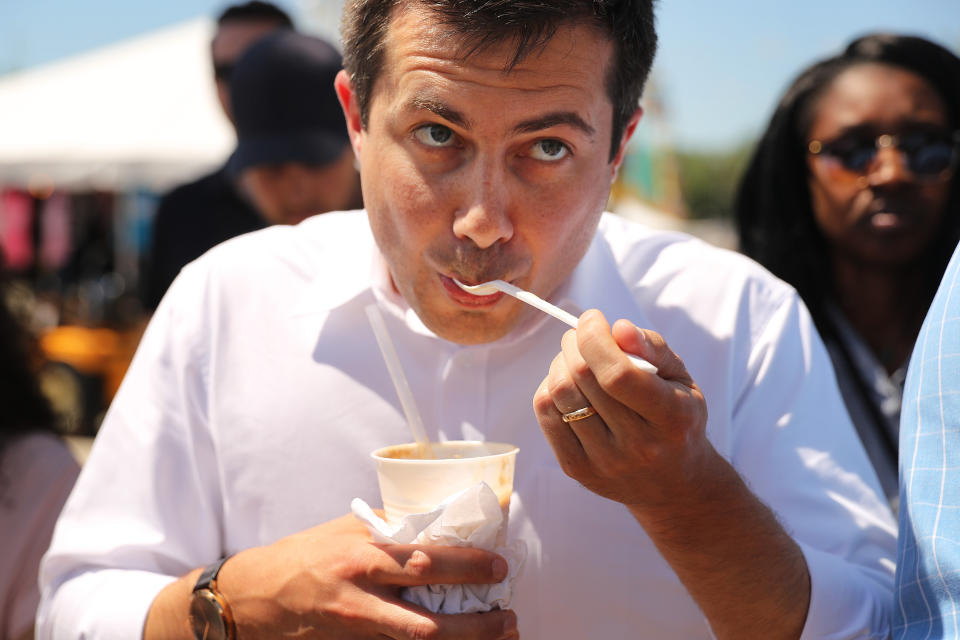 Buttigieg dips into a root beer float at the state fair on Aug. 13.