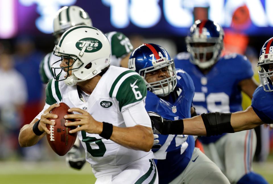 In this Aug. 24, 2013 photo, Jets QB Mark Sanchez (6) scrambles from Giants' Johnathan Hankins (74), and Mark Herzlich (58) before getting hit during the second half of a preseason game in East Rutherford. Sanchez was injured on the play. (AP Photo/Julio Cortez)