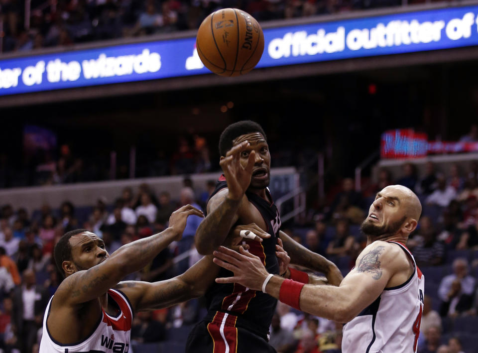 Washington Wizards forward Trevor Booker, left, Miami Heat forward Udonis Haslem, middle, and Wizaards center Marcin Gortat, from Poland, go for a rebound in the first half of an NBA basketball game, Monday, April 14, 2014, in Washington. (AP Photo/Alex Brandon)