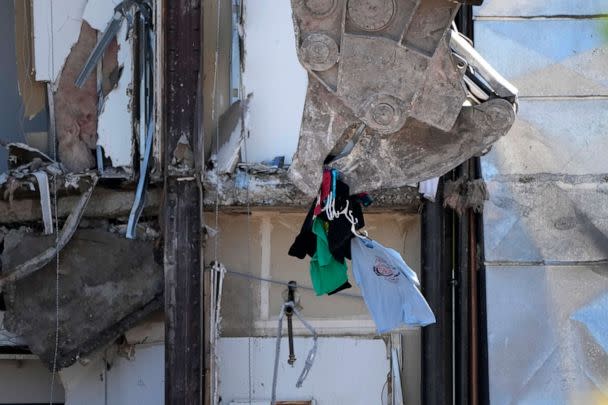 PHOTO: Clothing is removed from a closet during demolition at the site of a building collapse, June 12, 2023, in Davenport, Iowa. (Charlie Neibergall/AP)