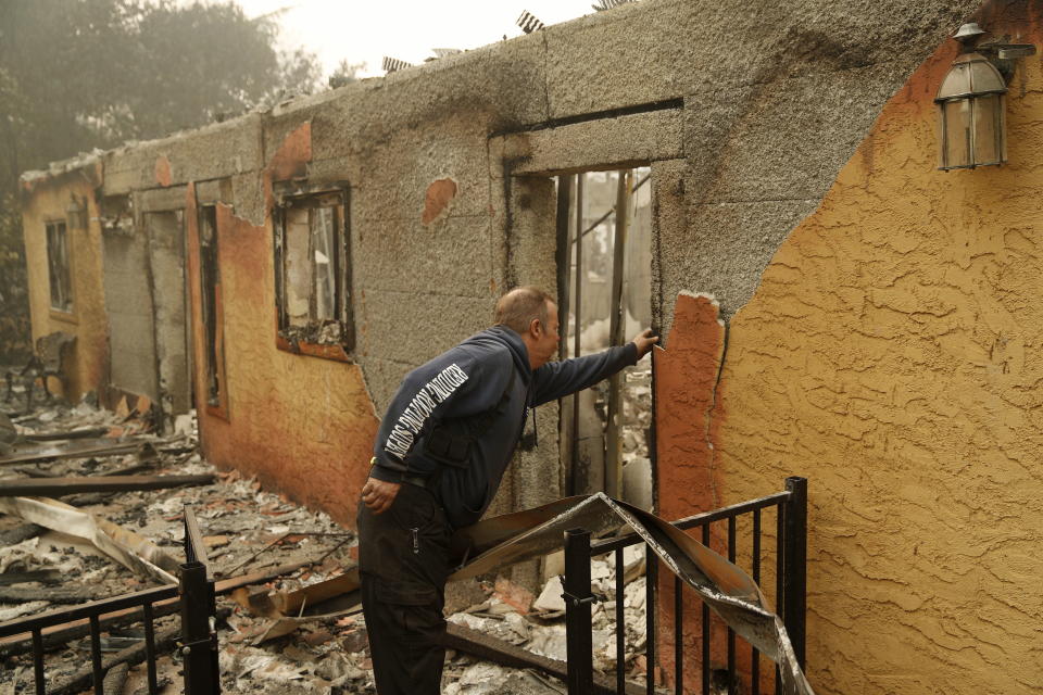 <p>Courtenay Jenvey inspects the remains of his neighbour’s home Saturday, Nov. 10, 2018, in Paradise, Calif. Jenvey was able to save his house during the fire.<br>(Photo from John Locher, AP) </p>