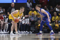 West Virginia guard Sean McNeil (22) is defended by Kansas guard Christian Braun (2) during the first half of an NCAA college basketball game in Morgantown, W.Va., Saturday, Feb. 19, 2022. (AP Photo/Kathleen Batten)