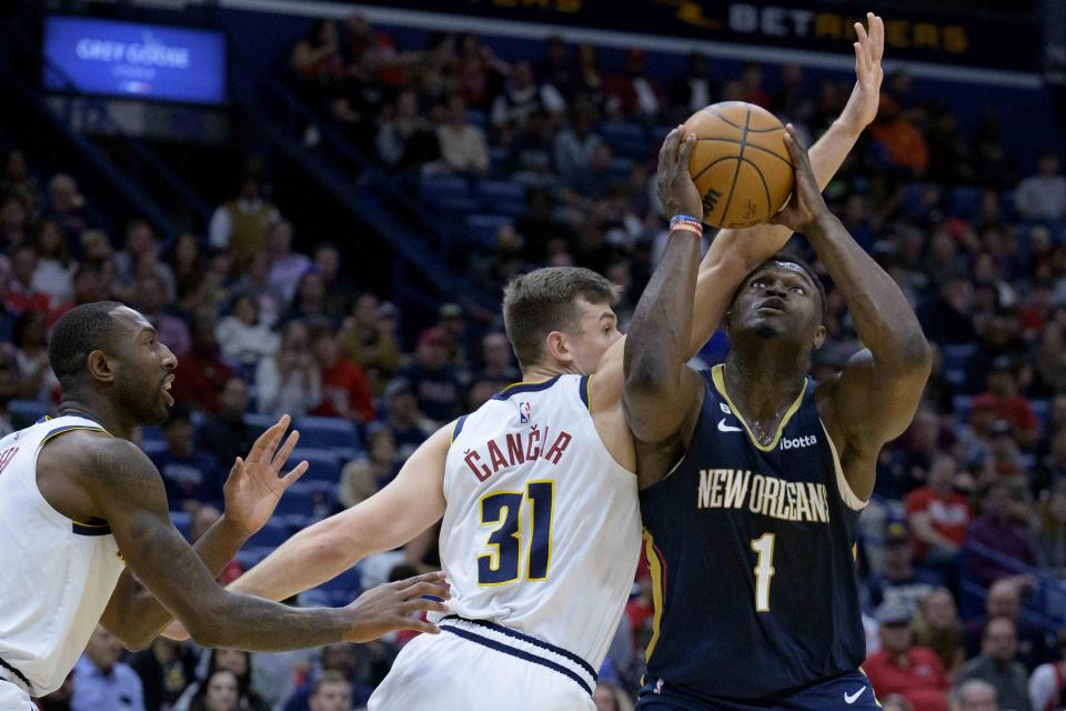 New Orleans Pelicans forward Zion Williamson (1) is fouled on his way to the basket by Denver Nuggets forward Vlatko Cancar (31) in the first half of an NBA basketball game in New Orleans, Sunday, Dec. 4, 2022. (AP Photo/Matthew Hinton)