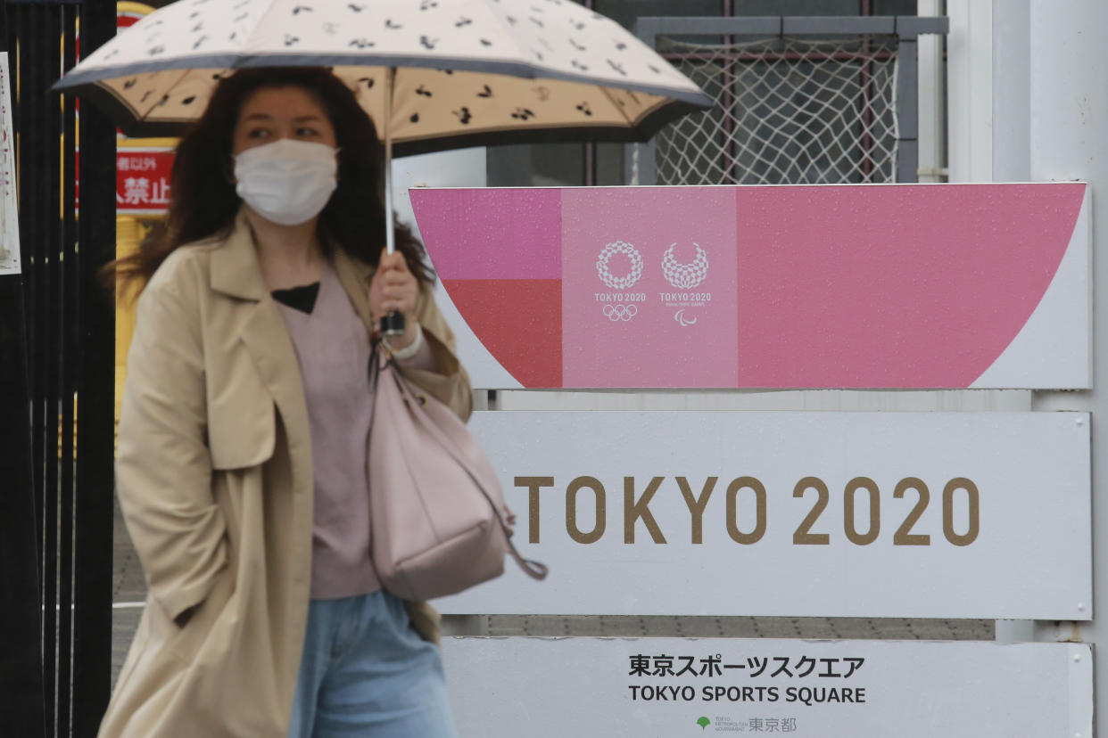 A woman walks by signage to promote the Olympic Games in Tokyo, Monday, April 5, 2021. (AP Photo/Koji Sasahara)
