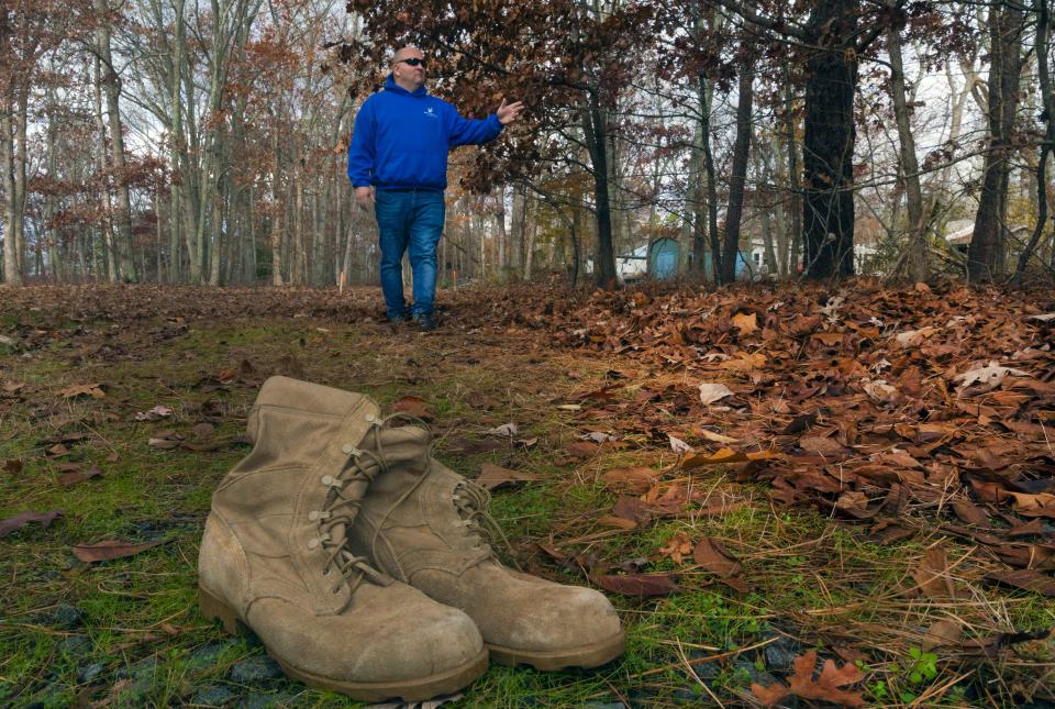 Paul Hulse stands on the future site of "Larry's Home" in Little Egg Harbor. The boots belonged to Larry Robertello; Hulse has been carrying them in his truck since his friend passed away in April 2022