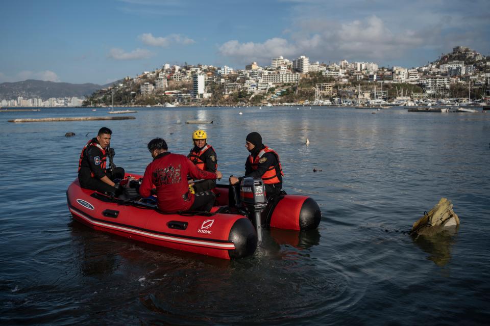 Firefighters and scuba divers search for bodies near sunken boats at a yacht club in Acapulco, Mexico, Saturday, Oct. 28, 2023, following Hurricane Otis.