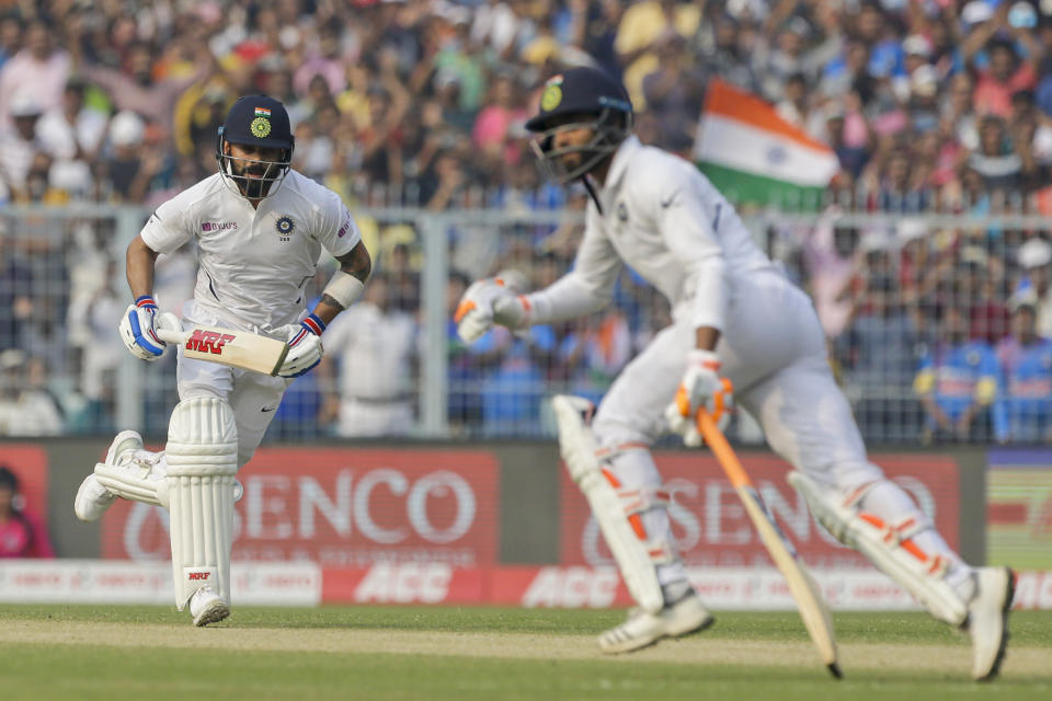 India's Virat Kohli, left, and Ravindra Jadeja run between the wickets during the second day of the second test cricket match between India and Bangladesh, in Kolkata, India, Saturday, Nov. 23, 2019. (AP Photo/Bikas Das)