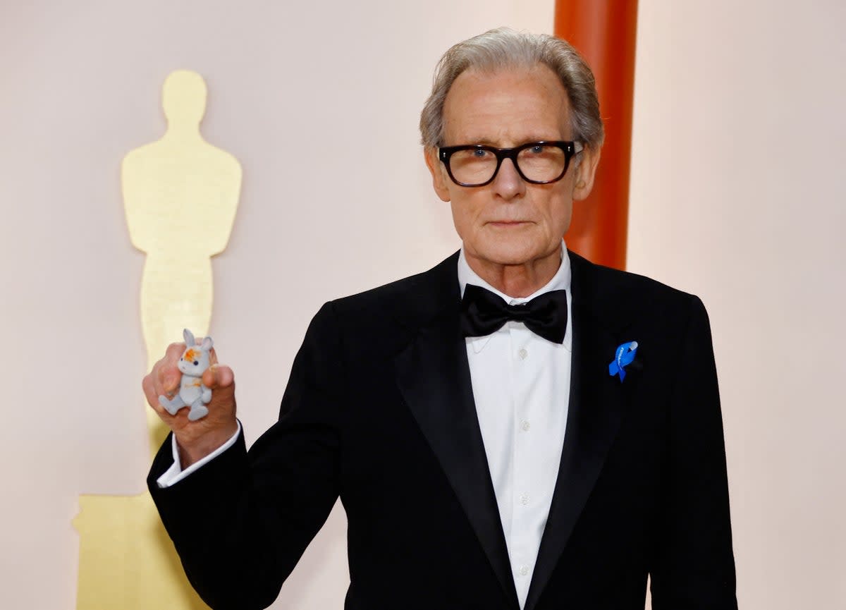Bill Nighy poses with his grandaughters Sylvanian rabbit at the Oscars (REUTERS)