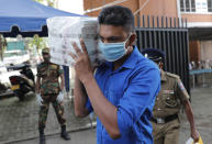 A Sri Lankan polling officer carries election material to dispatch them to polling centers ahead of the parliamentary elections in Colombo, Sri Lanka, Tuesday, Aug. 4, 2020. Sri Lankans are voting in parliamentary elections Wednesday that are expected to strengthen President Gotabaya Rajapaksa's grip on power. Parts of the party are also calling for a two-thirds majority in Parliament so it can amend the constitution to restore presidential powers curbed by a 2015 constitutional change. (AP Photo/Eranga Jayawardena)