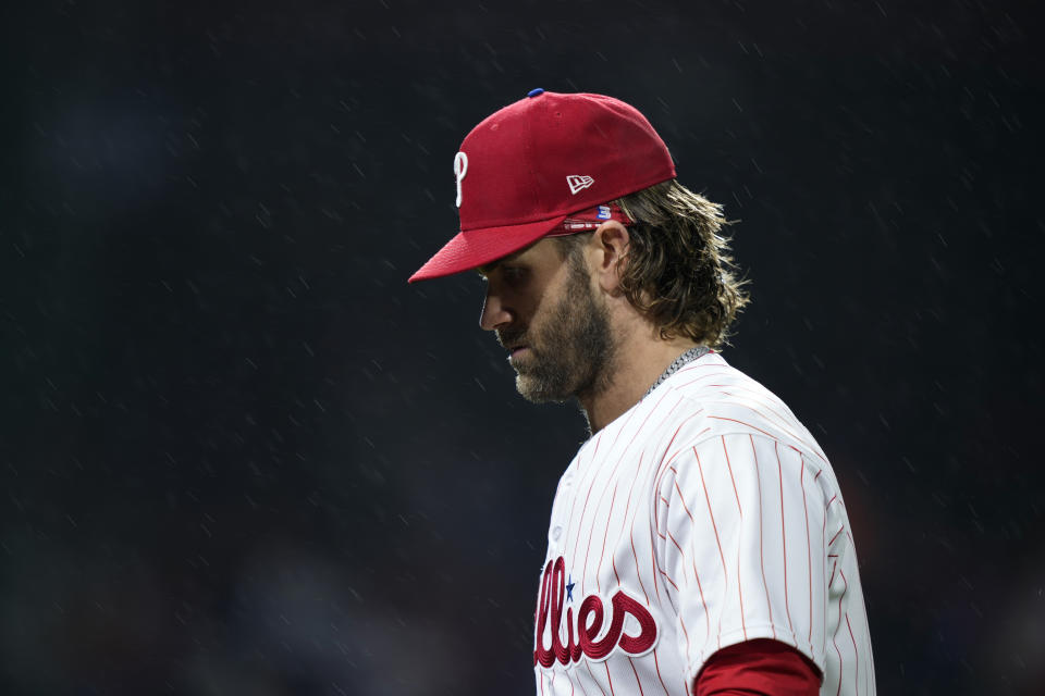 Philadelphia Phillies' Bryce Harper walks off the field as rain falls during the seventh inning of a baseball game against the New York Mets, Sunday, Sept. 24, 2023, in Philadelphia. (AP Photo/Matt Slocum)