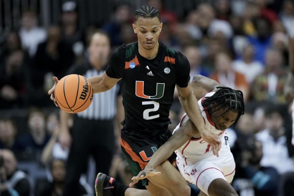 Houston guard Tramon Mark vies for the ball with Miami guard Isaiah Wong in the second half of a Sweet 16 college basketball game in the Midwest Regional of the NCAA Tournament Friday, March 24, 2023, in Kansas City, Mo. (AP Photo/Charlie Riedel)