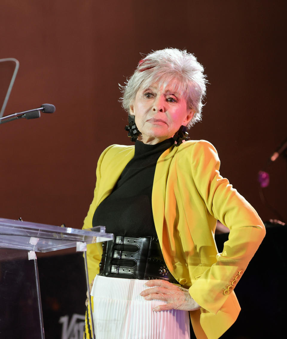 Moreno stands in front of a podium with her hands on her hips