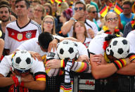 <p>Germany fans react as they watch the match at a public viewing area at Brandenburg Gate. REUTERS/Hannibal Hanschke </p>