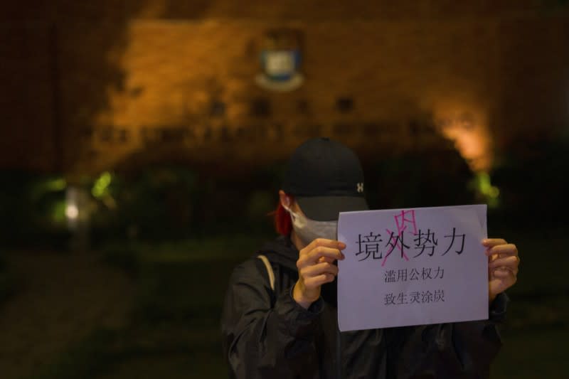 2022年11月29日，一名香港大學生高舉「境內勢力（境外的「外」字被塗掉，諷刺中共「境外勢力」介入的說法）濫用公權力、致生靈塗炭」的抗議標語。（美聯社）