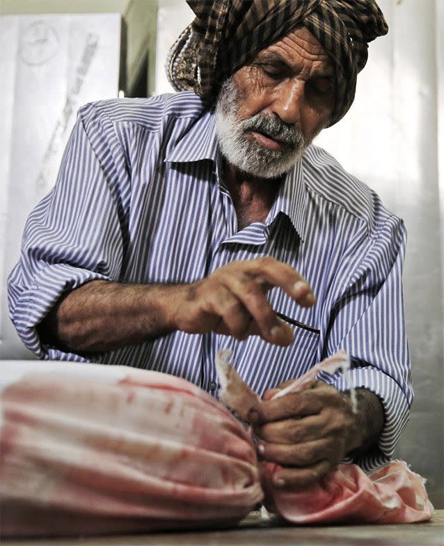 Palestinian Ahmed Jadallah, 75, prepares a body for burial at the morgue of Kamal Adwan hospital in Beit Lahiya, northern Gaza Strip, Thursday, July 24, 2014. Over the past three decades, the 75-year-old Jadallah has dressed hundreds of 'martyrs' _ those killed in conflict with Israel. He said his volunteer work fulfills an Islamic commandment and that he hopes it will earn him a place in paradise. Source: AP Photo