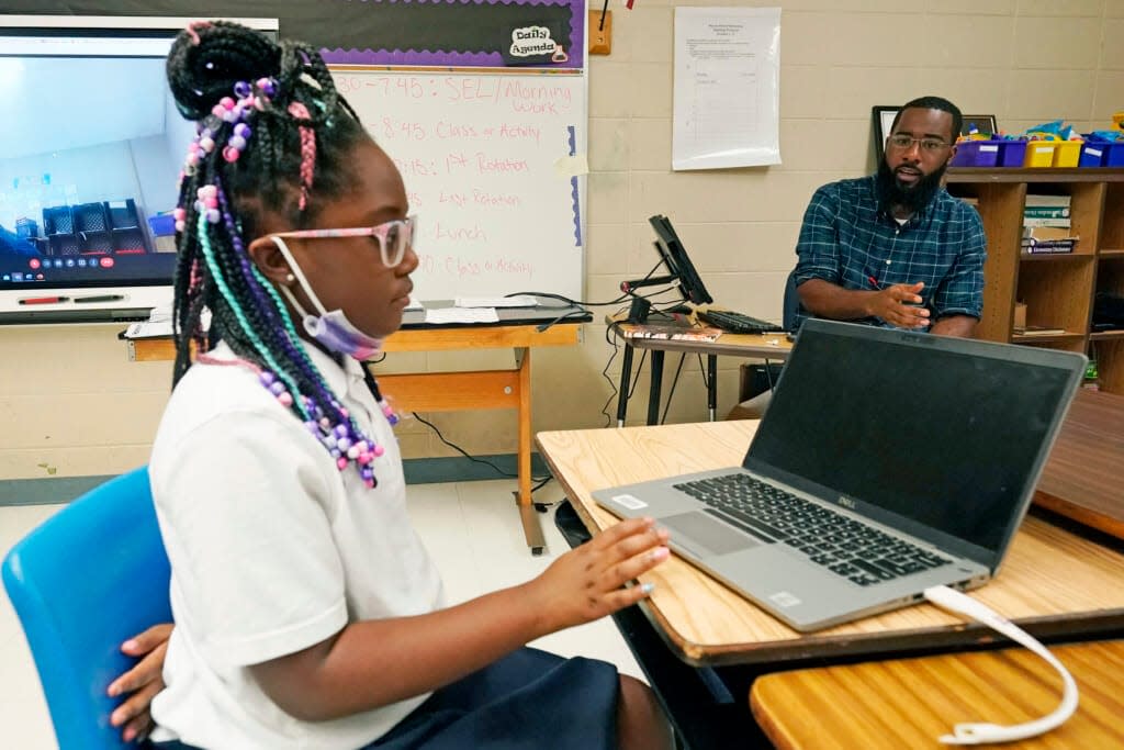 Ryan Johnson, a fifth-grade teacher at Pecan Park Elementary School, right, monitors his daughter Rylei, while she checks her homework schedule before they leave for home in Jackson, Miss., Tuesday, Sept. 6, 2022. (AP Photo/Rogelio V. Solis)