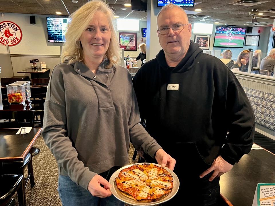 Linda and Pat Gibbons, who own Alumni Sports Cafe in Pembroke, present the Miss Peaches pizza. The special menu item is inspired by the American pit bull rescue of Barstool Sports founder Dave Portnoy, who has raised money for animal shelters across the country.