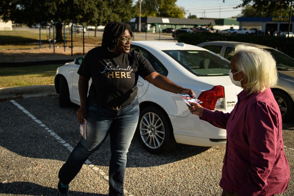 District 2 council member Shakeyla Ingram hands out campaign literature while talking to voters outside the polling site at Fayetteville Fire Station 1 on Tuesday, Oct. 10, 2023.