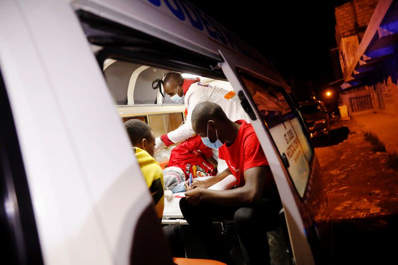 Medics examine a pregnant woman in an ambulance during the coronavirus night curfew in Nairobi