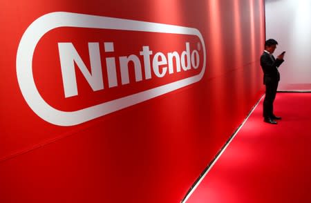 FILE PHOTO: A man stands in front of Nintendo's logo at the presentation ceremony of its new game console Switch in Tokyo