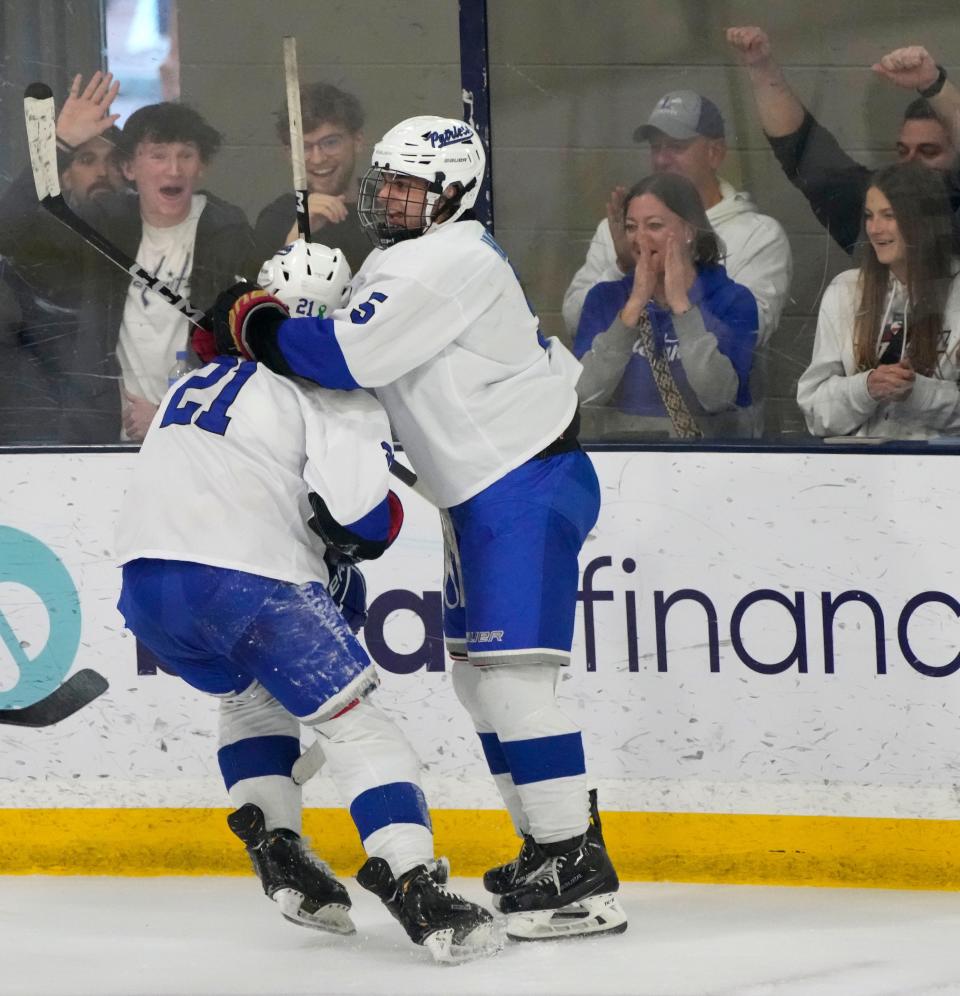 Charlie Hughes, right, and Jake Struck celebrate a goal during Olentangy Liberty's 10-1 win over Upper Arlington in the district final Saturday at OhioHealth Ice Haus.
