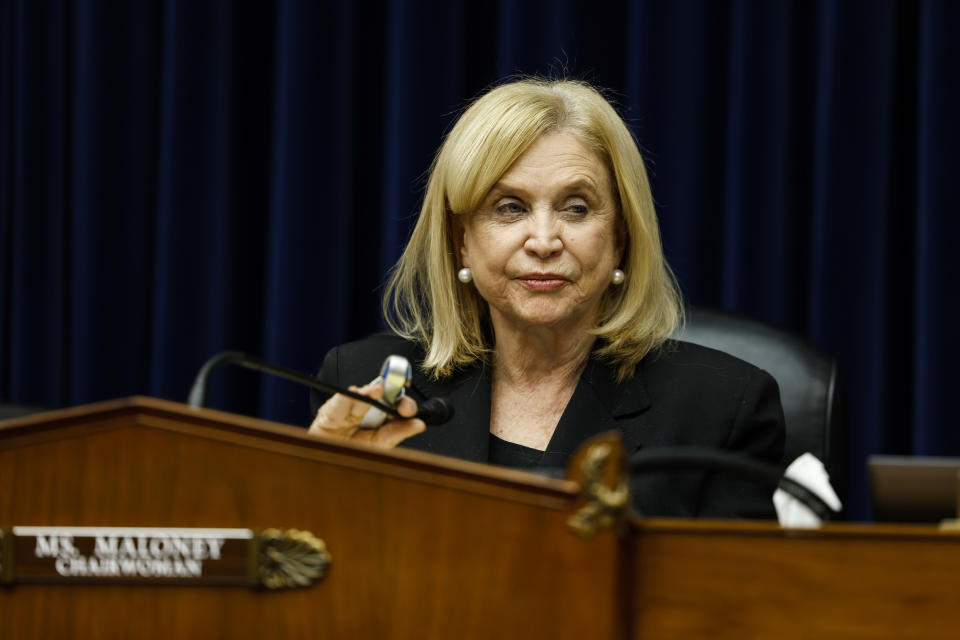 House Oversight Committee Chairwoman Carolyn Maloney holds a microphone as she sits at a hearing.