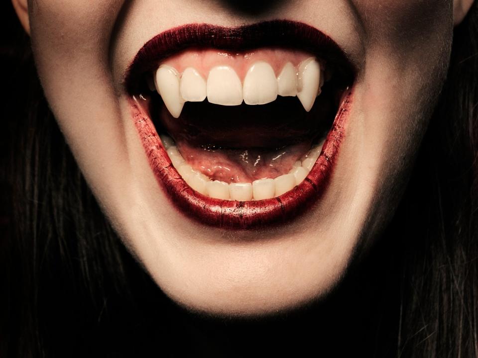 A stock images shows someone whose teeth have been modified to look like vampire teeth.