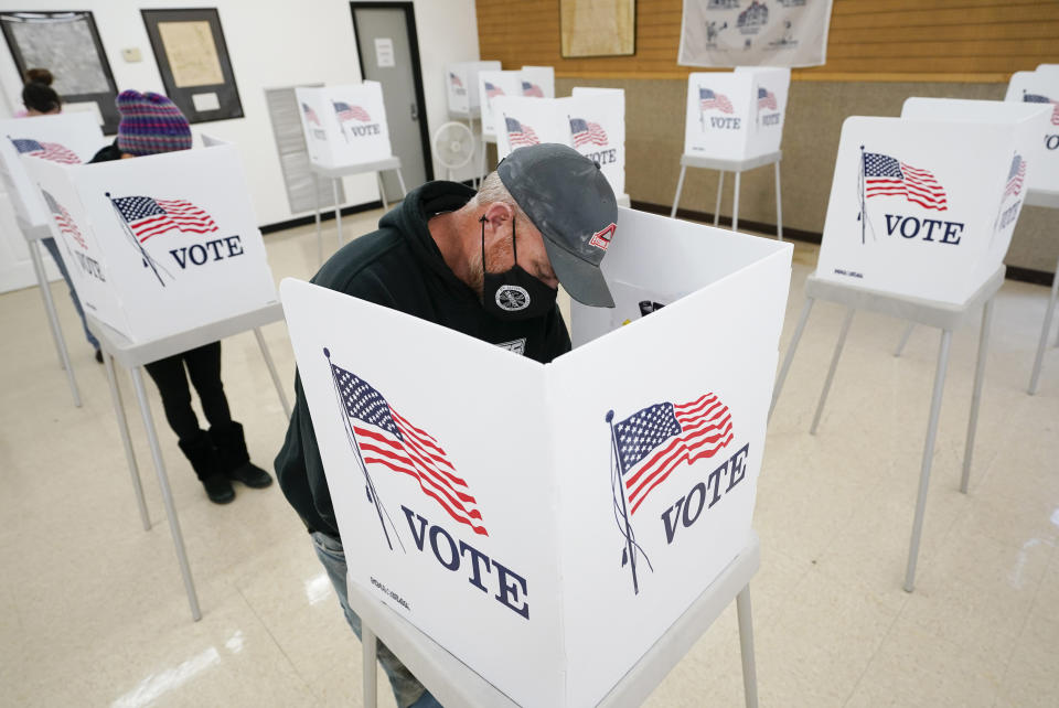 Chris Helps, of Earlham, Iowa, fills out his ballot during early voting, Tuesday, Oct. 20, 2020, in Adel, Iowa. (AP Photo/Charlie Neibergall)