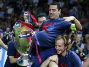 FILE - In this Saturday, June 6, 2015 file photo Barcelona's Xavi Hernandez is carried by his teammates as he holds the trophy after the Champions League final soccer match between Juventus Turin and FC Barcelona at the Olympic stadium in Berlin. X is for Xavi. Four-time winner Xavi Hernandez formed a formidable midfield partnership with Andres Iniesta and helped give the Catalan giants four wins in 9 years from 2006. (AP Photo/Luca Bruno, File)