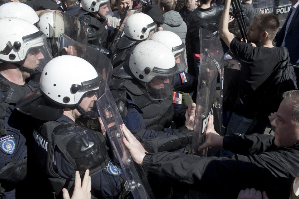 Riot police clash with protesters in Belgrade, Serbia, Sunday, March 17, 2019. As Serbian president Aleksandar Vucic held a news conference in the presidency building in downtown Belgrade, thousands of opposition supporters gathered in front demanding his resignation. Skirmishes with riot police were reported, including officers firing tear gas against the protesters who have pledged to form a human chain around the presidency to prevent Vucic from leaving the building. (AP Photo/Marko Drobnjakovic)