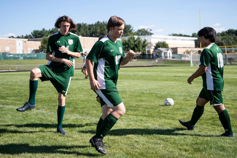 Junior varsity soccer player Sviat Schut, left, and Fedir Smyrnov, center, both of Ukraine, practice with teammates before a game against Allendale at the Grand Rapids West Catholic High School on Wednesday, Sept. 7, 2022.