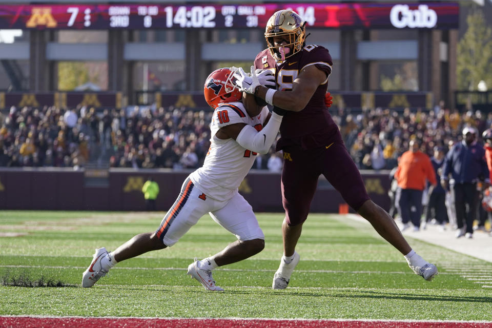Minnesota tight end Brevyn Spann-Ford, right, runs with the ball to score a 31-yard touchdown as Illinois defensive back Miles Scott, left, attempts a tackle during the first half of an NCAA college football game, Saturday, Nov. 4, 2023, in Minneapolis. (AP Photo/Abbie Parr)