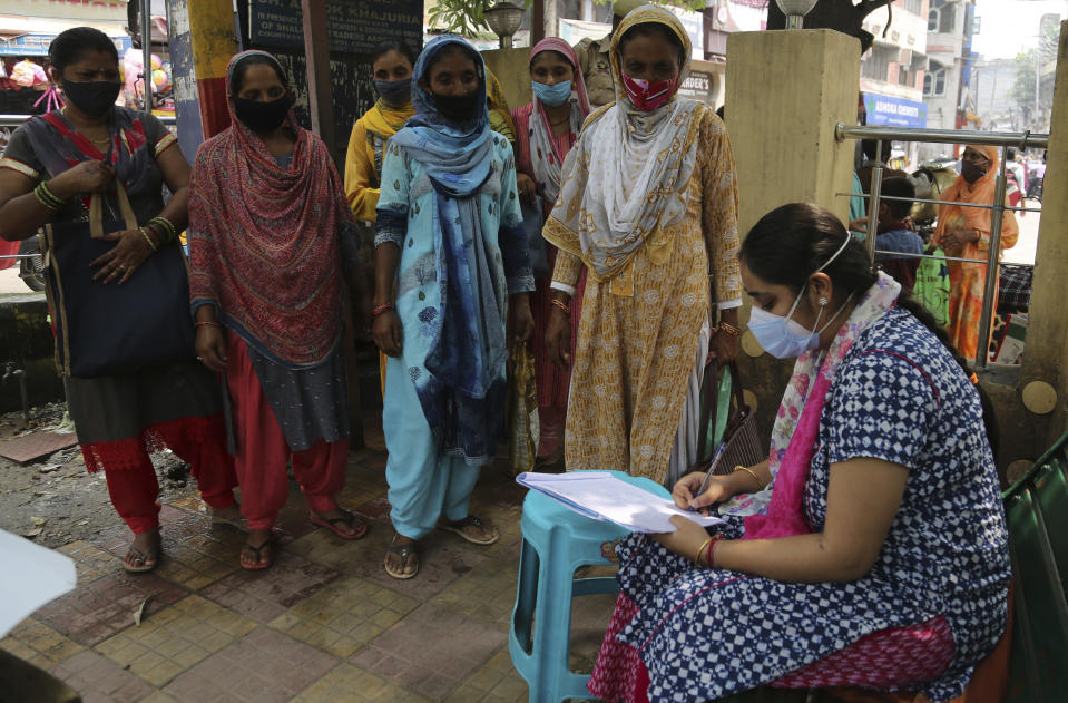 Women stand to register their names to test for COVID-19 at busy market in Jammu, India, Wednesday, Aug. 25, 2021. (AP Photo/Channi Anand)