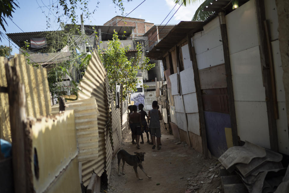 In this June 20, 2019 photo, friends of Kaua Rozario, who was killed by a stray bullet, walks in an alley at the Vila Alianca slum in Rio de Janeiro, Brazil. Kaua's father said witnesses told him the boy was hit by police gunfire. But police haven't acknowledged shooting the boy, saying the case is under investigation. (AP Photo/Leo Correa)