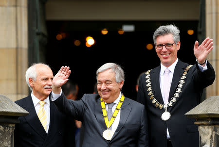 Charlemagne Prize (Karlspreis) recipient, United Nations Secretary-General Antonio Guterres, waves from the town hall balcony, flanked by former Mayor Juergen Linden and Mayor Marcel Philipp during the ceremony in Aachen, Germany May 30, 2019. REUTERS/Thilo Schmuelgen