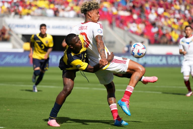 El venezolano Jhonder Cádiz (de blanco) aguanta el balón ante la marca de un defensa ecuatoriano en partido del Grupo B de la Copa América jugado el 22 de junio de 2024 en el Levi's Stadium de Santa Clara, California (Thearon W. Henderson)